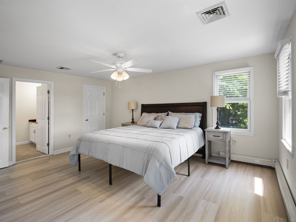 13 Plain Street Upton, MA 01568 - Photo 26 of 42 a bedroom with a bed and a chandelier