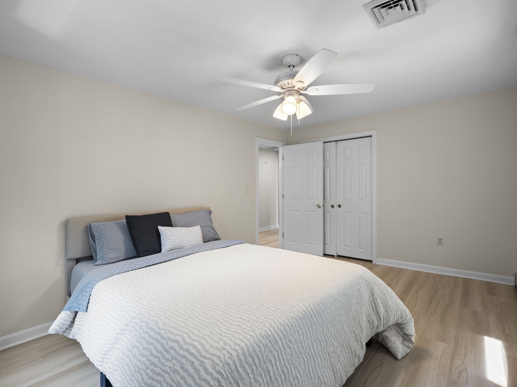 13 Plain Street Upton, MA 01568 - Photo 29 of 42 a bedroom with a large bed and wooden floor