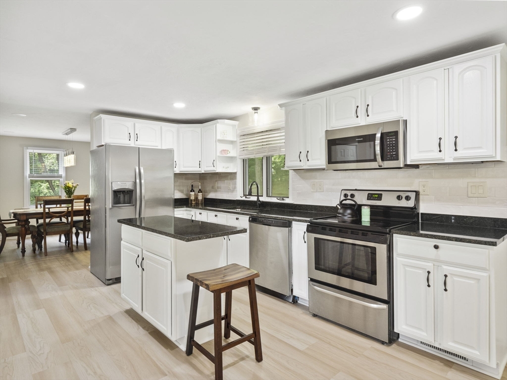 13 Plain Street Upton, MA 01568 - Photo 10 of 42 a kitchen with granite countertop white cabinets and stainless steel appliances