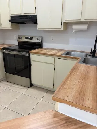a kitchen with a stove and a white cabinets