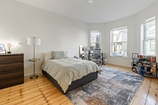 a large bedroom with a bed a table and chair