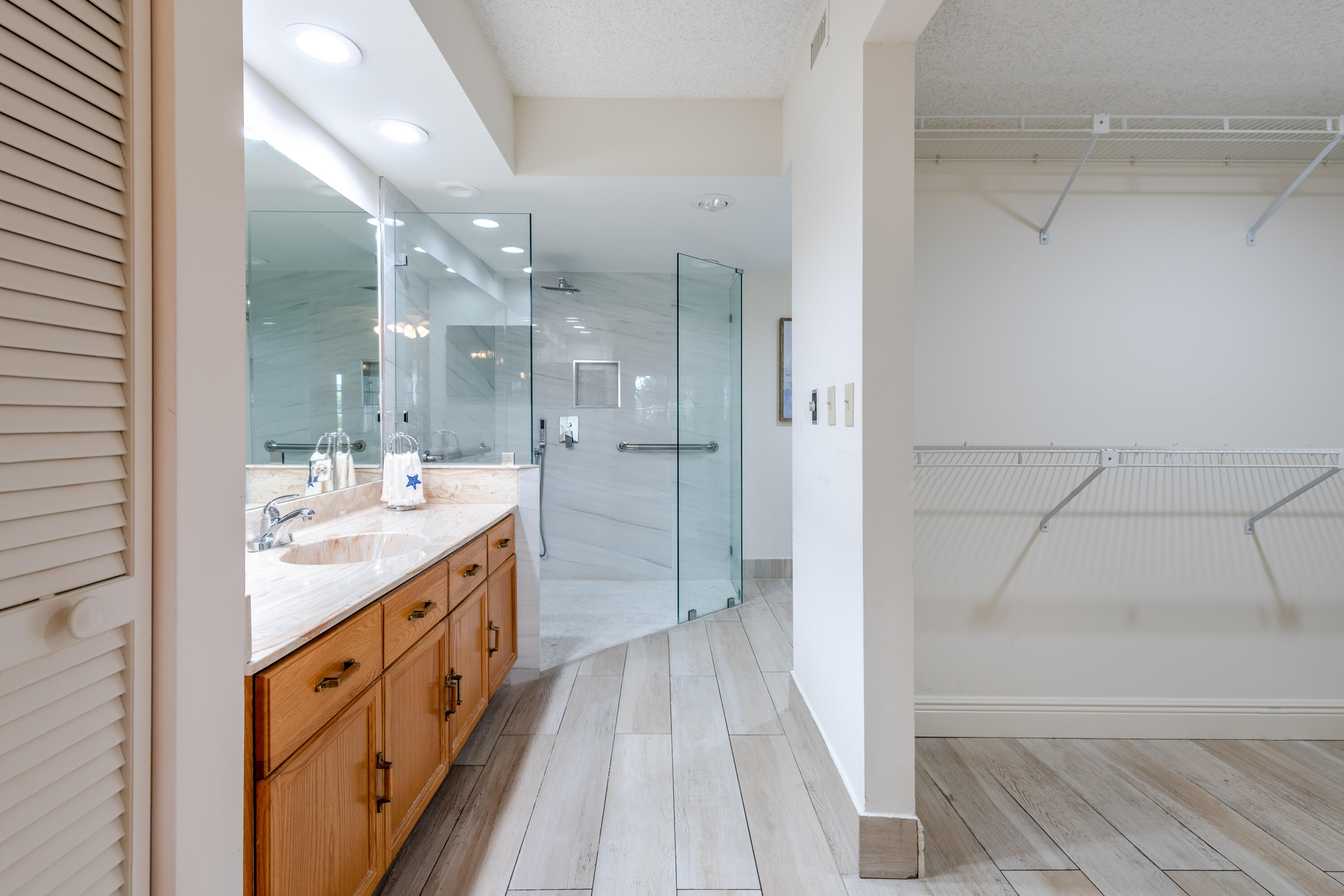 7527 Glendevon Lane, Unit 803 Delray Beach, FL 33446 - Photo 21 of 35 a spacious bathroom with a granite countertop sink mirror and shower
