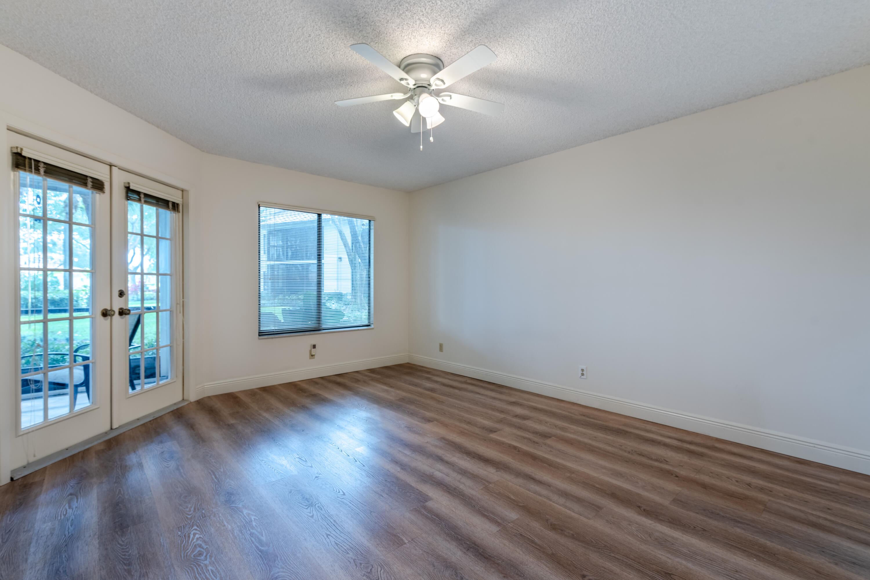 7527 Glendevon Lane, Unit 803 Delray Beach, FL 33446 - Photo 23 of 35 an empty room with wooden floor and windows