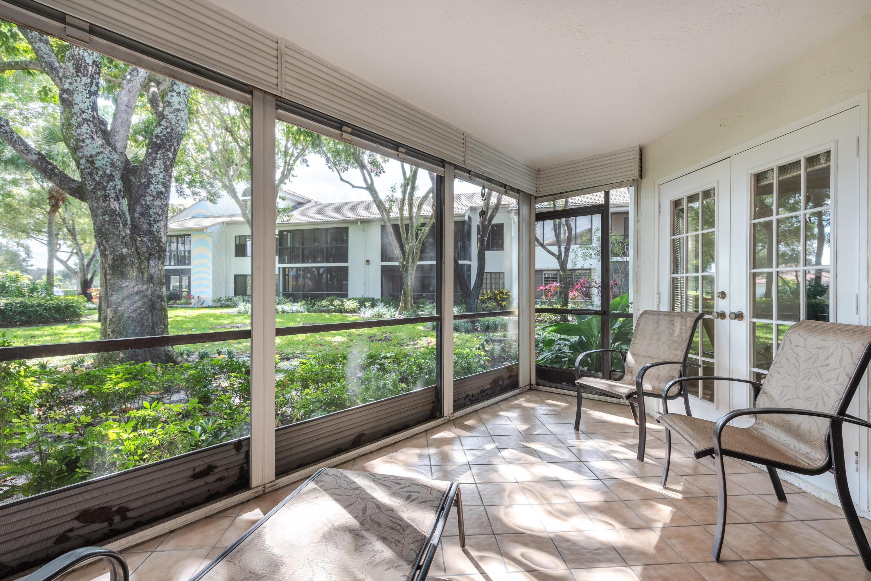 7527 Glendevon Lane, Unit 803 Delray Beach, FL 33446 - Photo 25 of 35 a view of a patio with a table chairs and a backyard