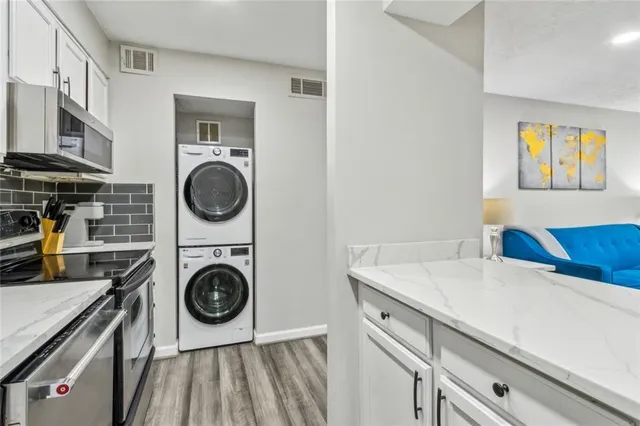 a utility room with dryer washer and a view of living room