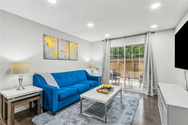 a living room with furniture a flat screen tv and a table