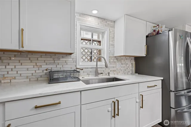 a kitchen with white cabinets and refrigerator