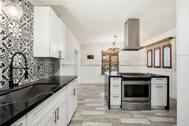 a kitchen with stainless steel appliances granite countertop a sink stove and cabinets