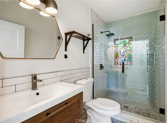 a bathroom with a sink a toilet and shower