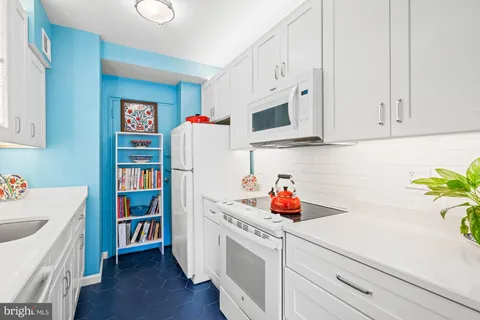 a kitchen with stainless steel appliances a white cabinets wooden floor and a sink