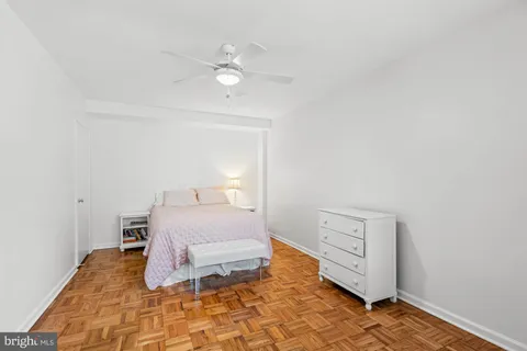a bedroom with a bed and a lamp on dresser