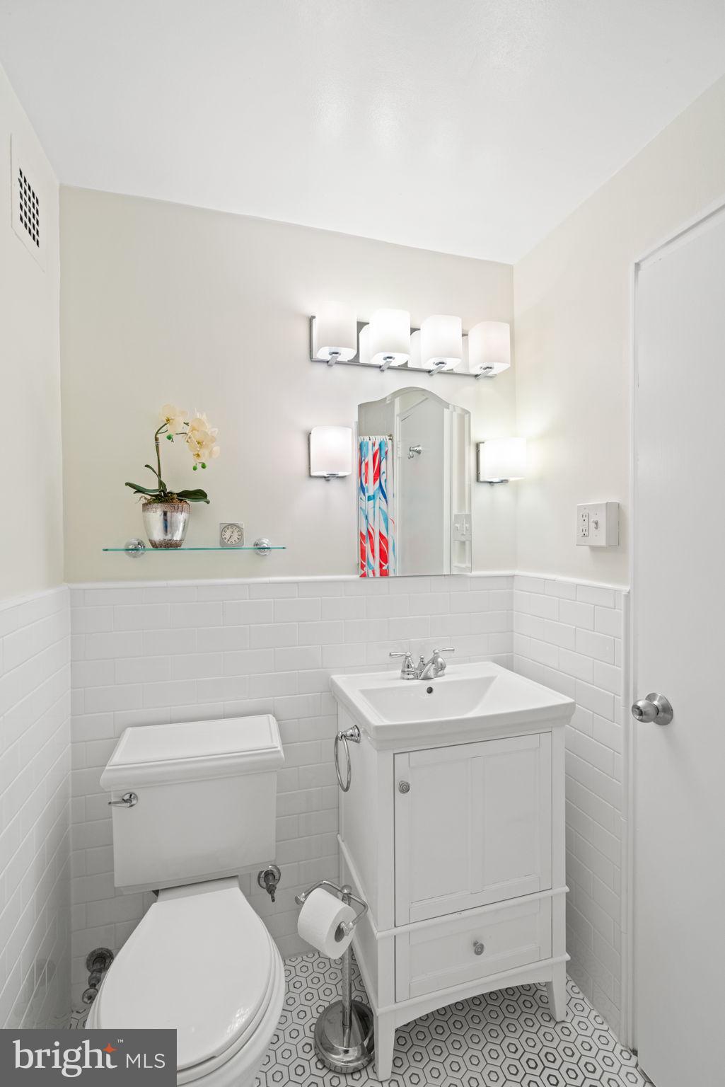 4740 Connecticut Avenue Northwest, Unit 204 Washington, DC 20008 - Photo 23 of 33 a bathroom with a sink vanity mirror and toilet