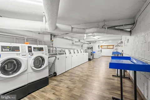 a utility room with dryer washer and a view of living room