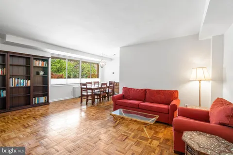 a living room with furniture and a dining table with bookshelf