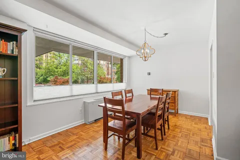 a dining room with furniture a rug and a floor to ceiling window