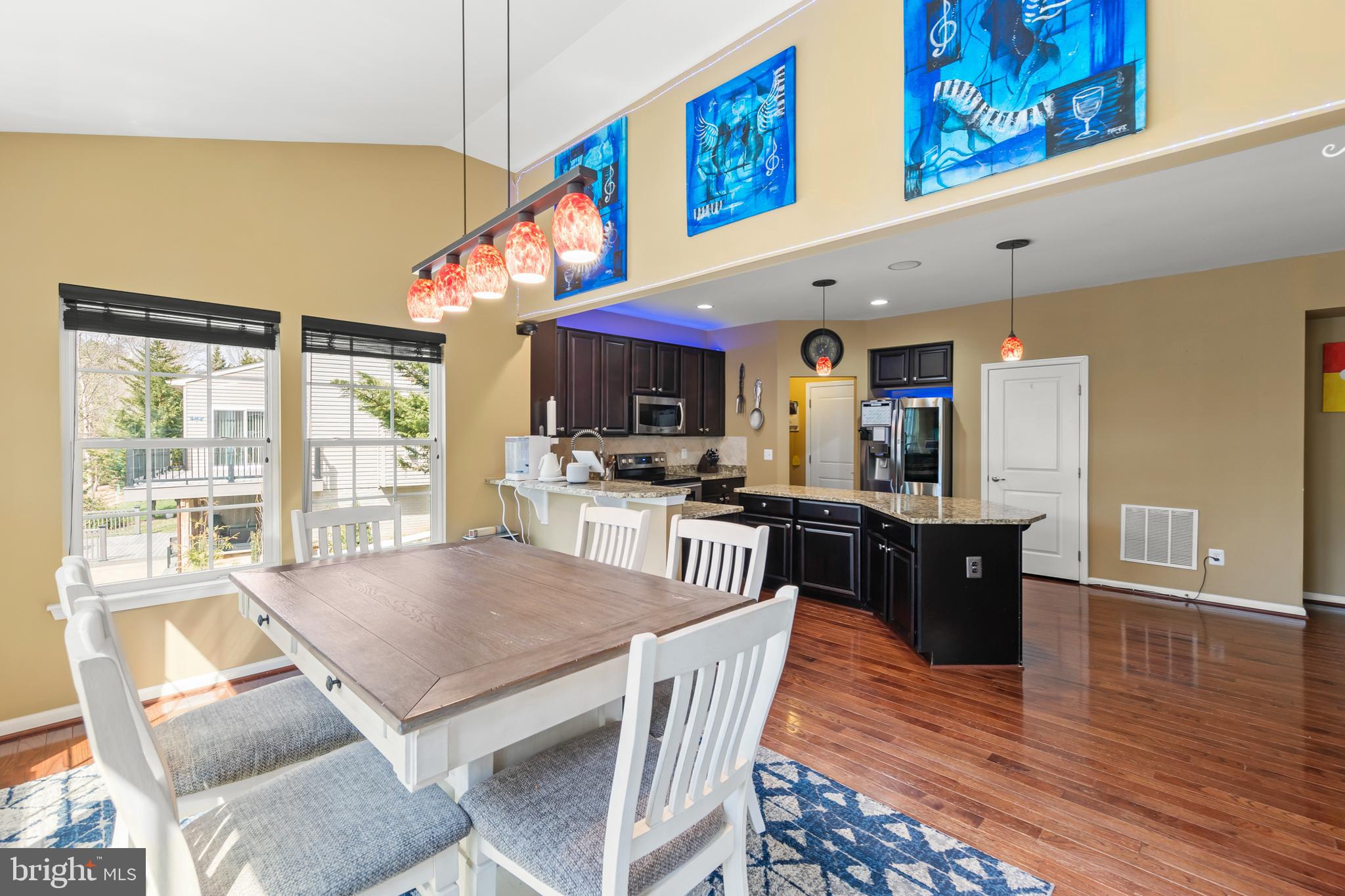 155 Merlot Drive Stephenson, VA 22656 - Photo 22 of 69 a kitchen with stainless steel appliances granite countertop a stove a refrigerator a kitchen island a dining table and chairs with wooden floor