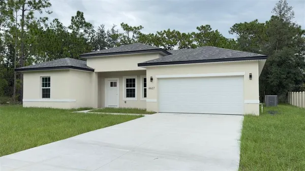a front view of a house with a garden and yard
