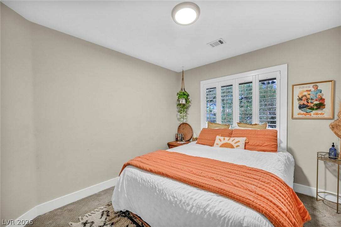 1234 Sunfire Street Henderson, NV 89014 - Photo 19 of 40 A tranquil bedroom features well-lit walls and elegant window shutters, fostering a serene atmosphere.
