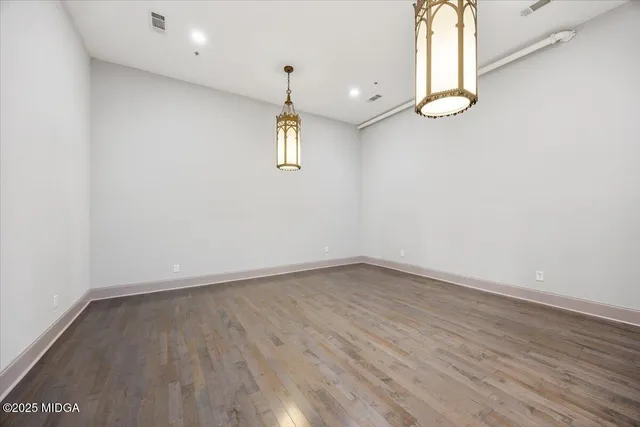 an empty room with wooden floor and window