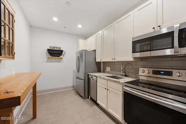 a kitchen with stainless steel appliances granite countertop a stove microwave and refrigerator