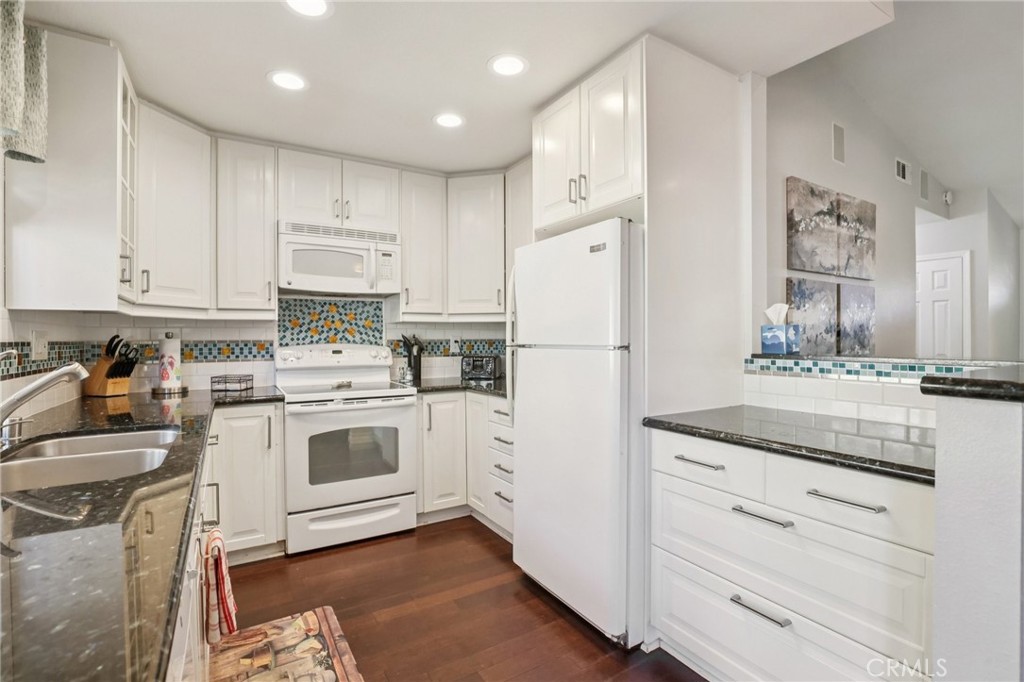 27191 Valleymont Road Lake Forest, CA 92630 - Photo 12 of 37 a kitchen with granite countertop cabinets and white appliances