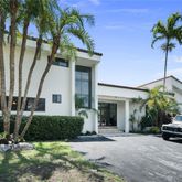 a view of a house with a small yard and palm trees