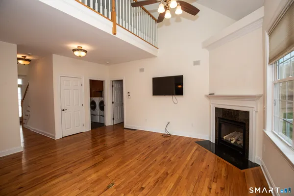 a view of empty room with wooden floor and fireplace
