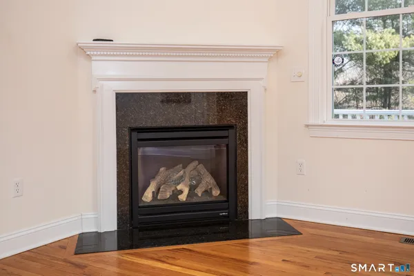 a living room with a fireplace and wooden floor