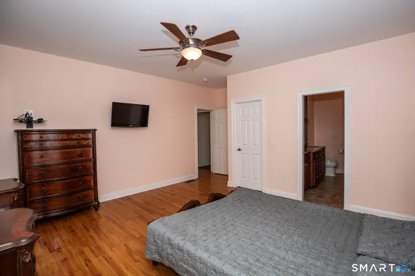 a bedroom with a bed and a ceiling fan