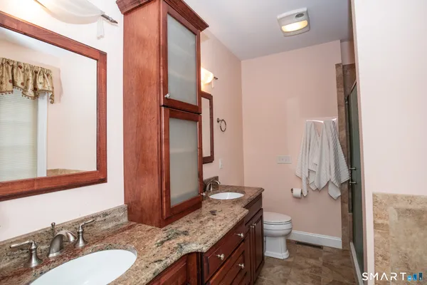 a bathroom with a granite countertop sink toilet and shower