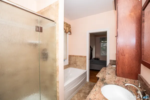 a bathroom with a granite countertop sink toilet and shower