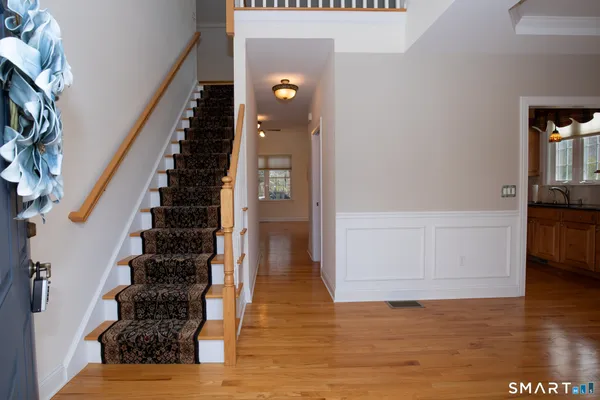a view of entryway and hall with wooden floor