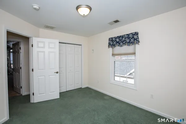 an empty room with windows and closet