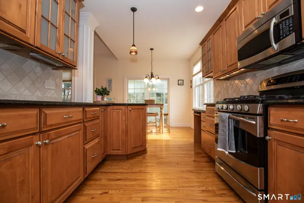 a kitchen with stainless steel appliances granite countertop a stove a sink and a refrigerator