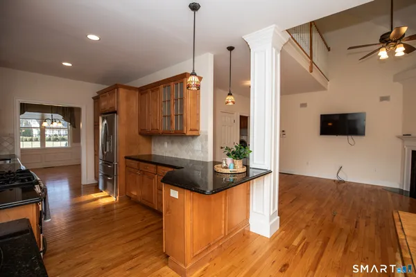 a kitchen with stainless steel appliances granite countertop a refrigerator a stove and a wooden floors