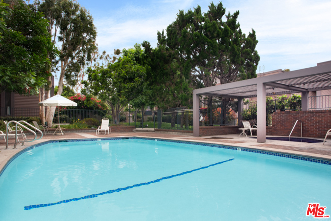 4425 Alla Road, Unit 6 Marina del Rey, CA 90292 - Photo 33 of 35 a view of a swimming pool with lawn chairs under an umbrella