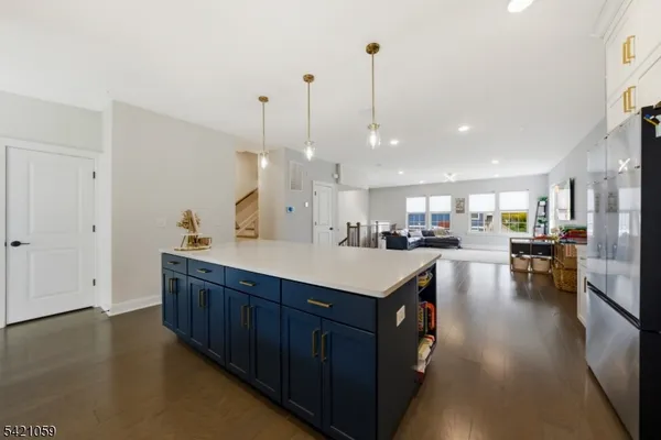 a kitchen with stainless steel appliances granite countertop a sink a stove and a wooden floor