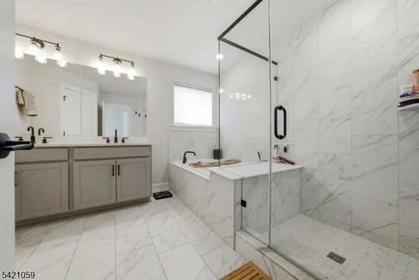 a bathroom with a sink a toilet a mirror and shower