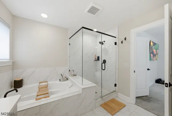 a bathroom with a tub shower and sink