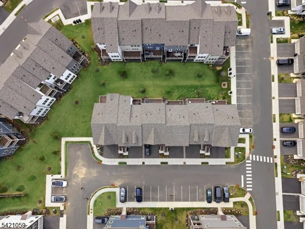 an aerial view of residential houses with outdoor space and parking