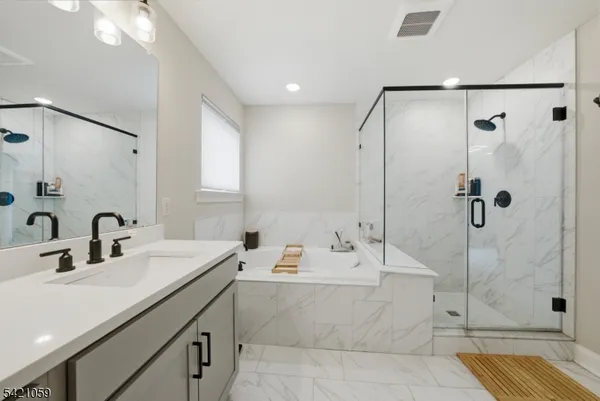 a bathroom with a double vanity sink mirror and shower