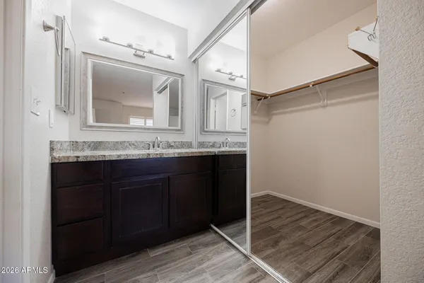 a bathroom with a granite countertop sink and a mirror