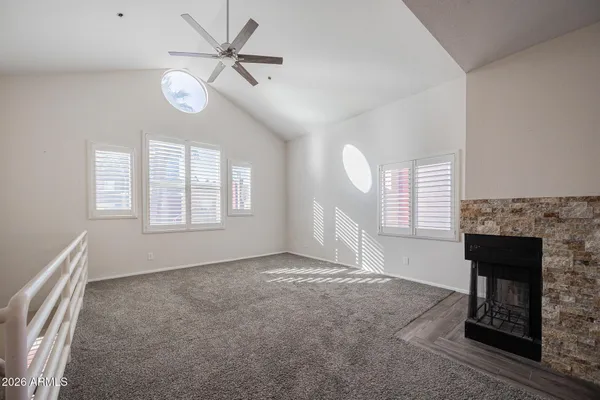 an empty room with windows and fireplace