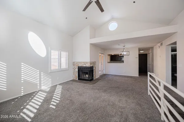 a view of an empty room with fireplace and a window