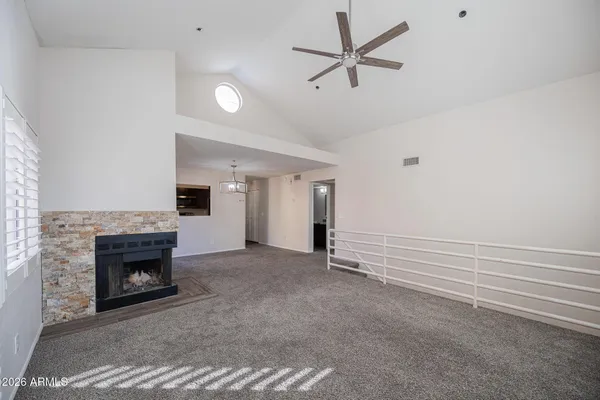 a view of a livingroom with a fireplace a ceiling fan and a fireplace