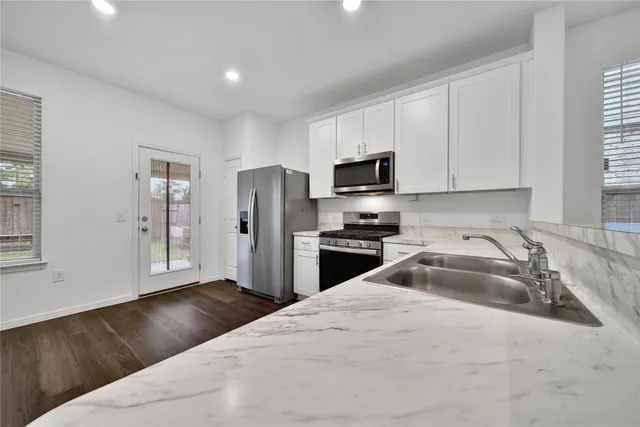 a kitchen with granite countertop a refrigerator and a sink