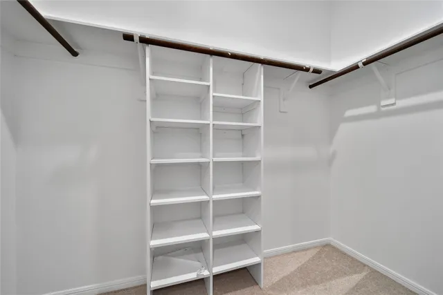 a view of walk in closet with empty racks