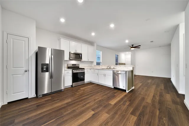 a kitchen with a refrigerator and a stove top oven