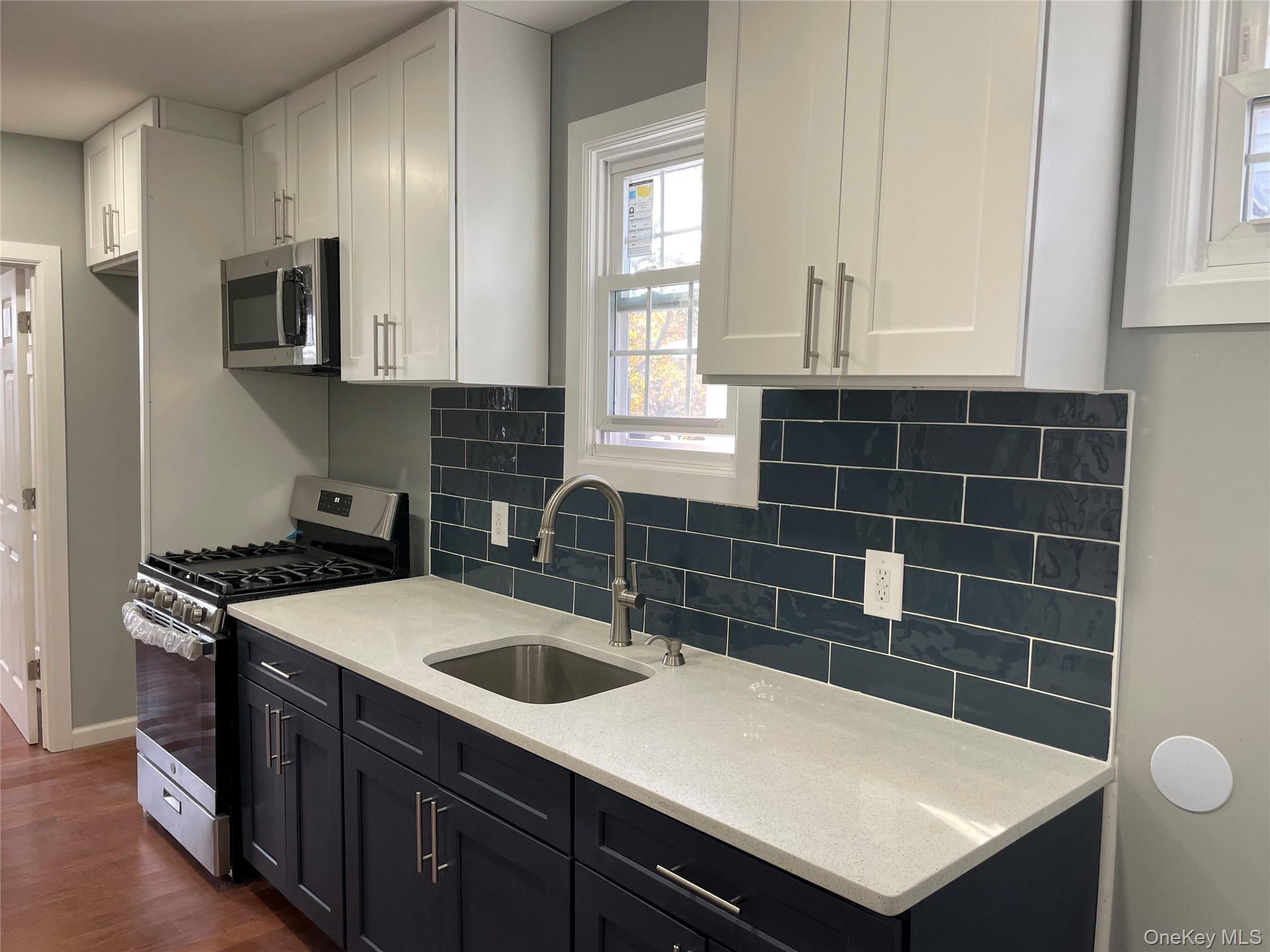 131-08 Sutter Avenue Queens, NY 11420 - Photo 8 of 21 a kitchen with a sink a stove and cabinets