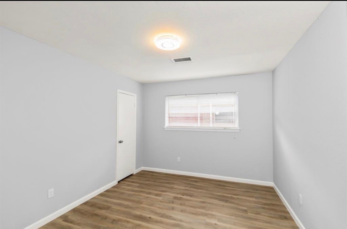 7515 Jason Street Houston, TX 77074 - Photo 18 of 24 a view of an empty room with wooden floor and a window